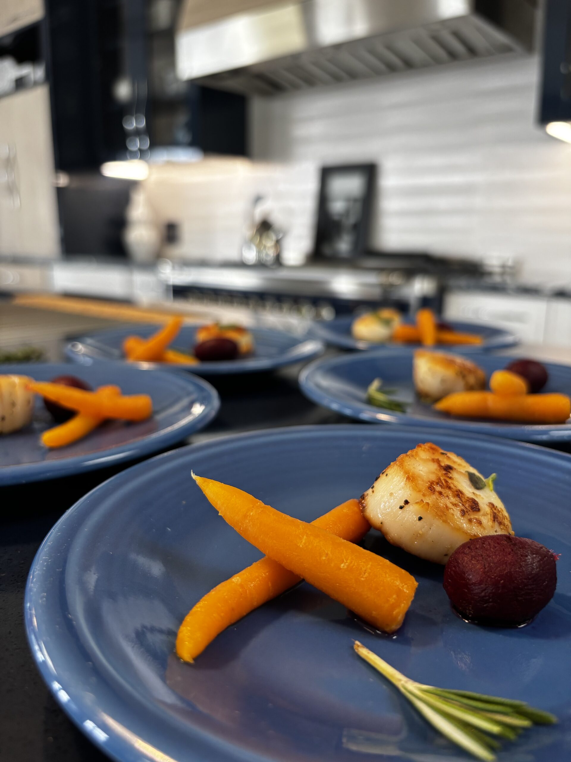 Plates of seared scallops and carrots.| ANA MARIA'S CATERING