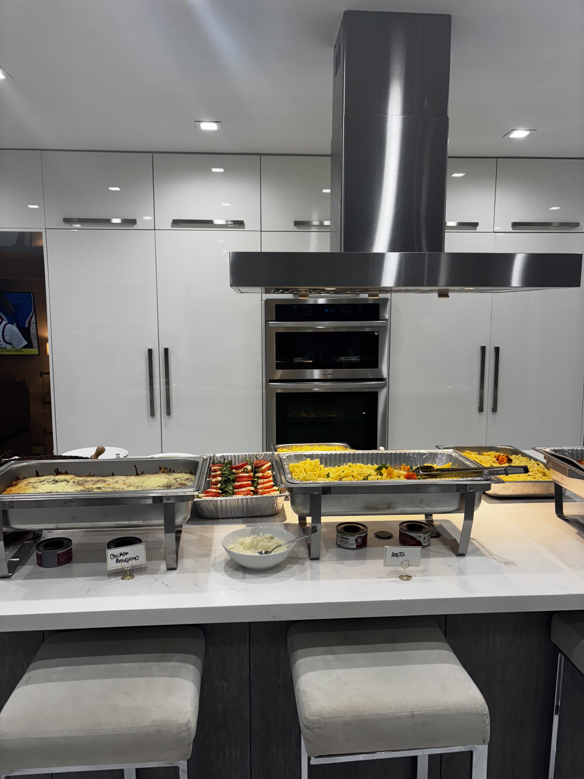Kitchen island with chafing dishes of food.| ANA MARIA'S CATERING