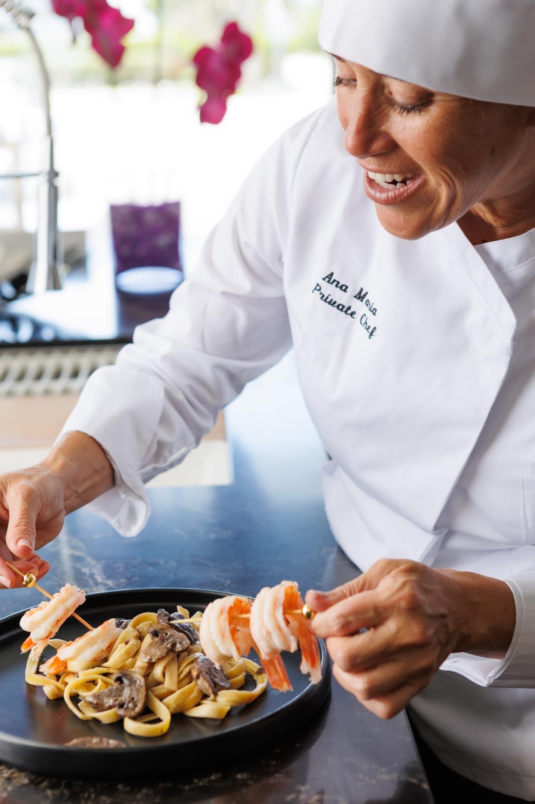 Chef Ana Maria plating a shrimp and pasta dish