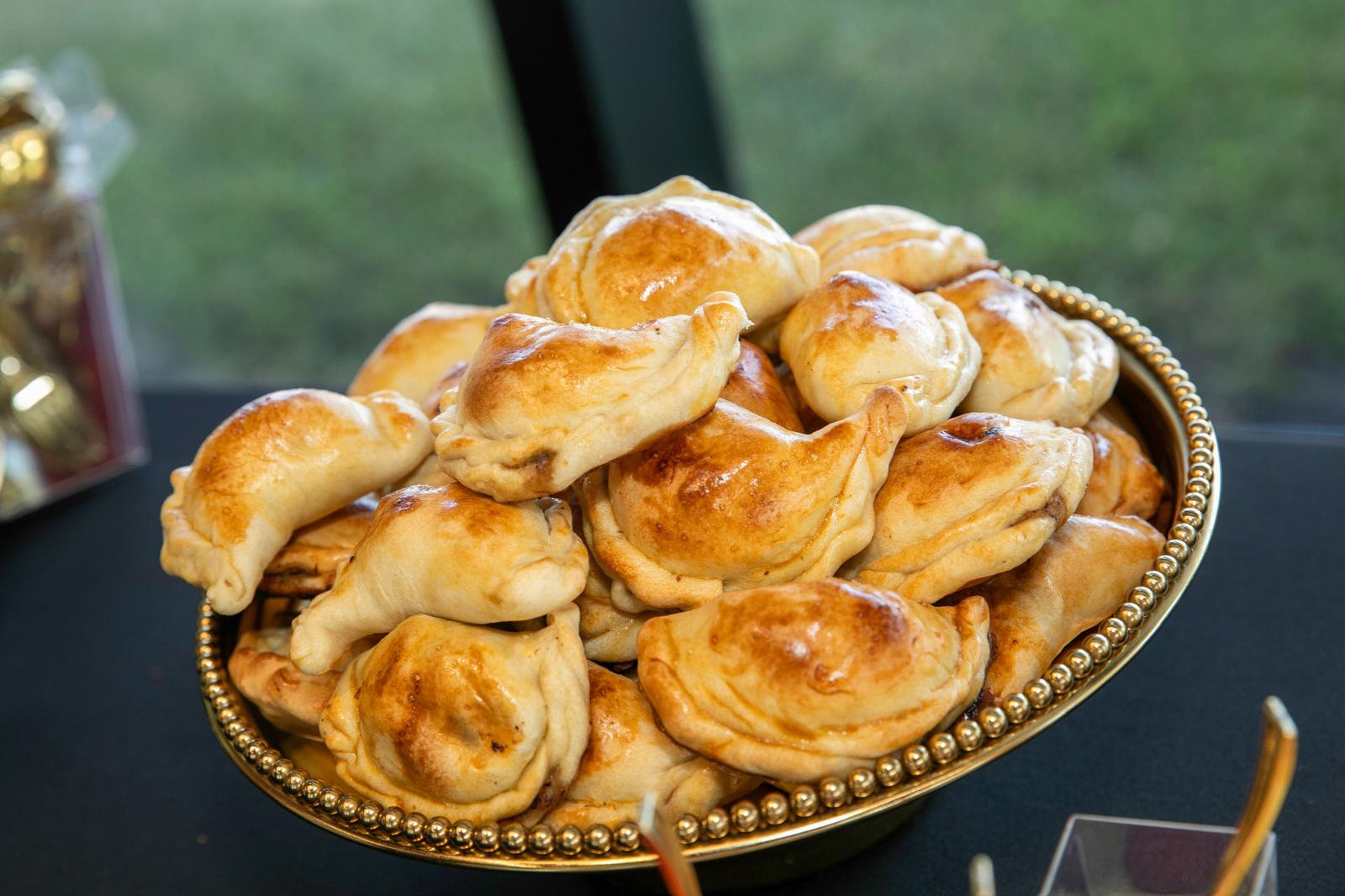 Golden empanadas served on a gold platter