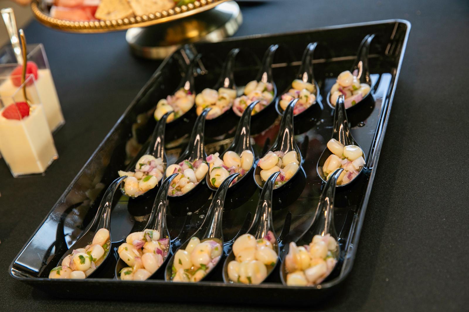 Ceviche tasting spoons arranged on a black tray