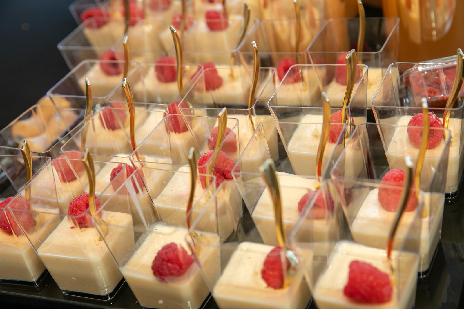 Individual dessert cups topped with fresh raspberries