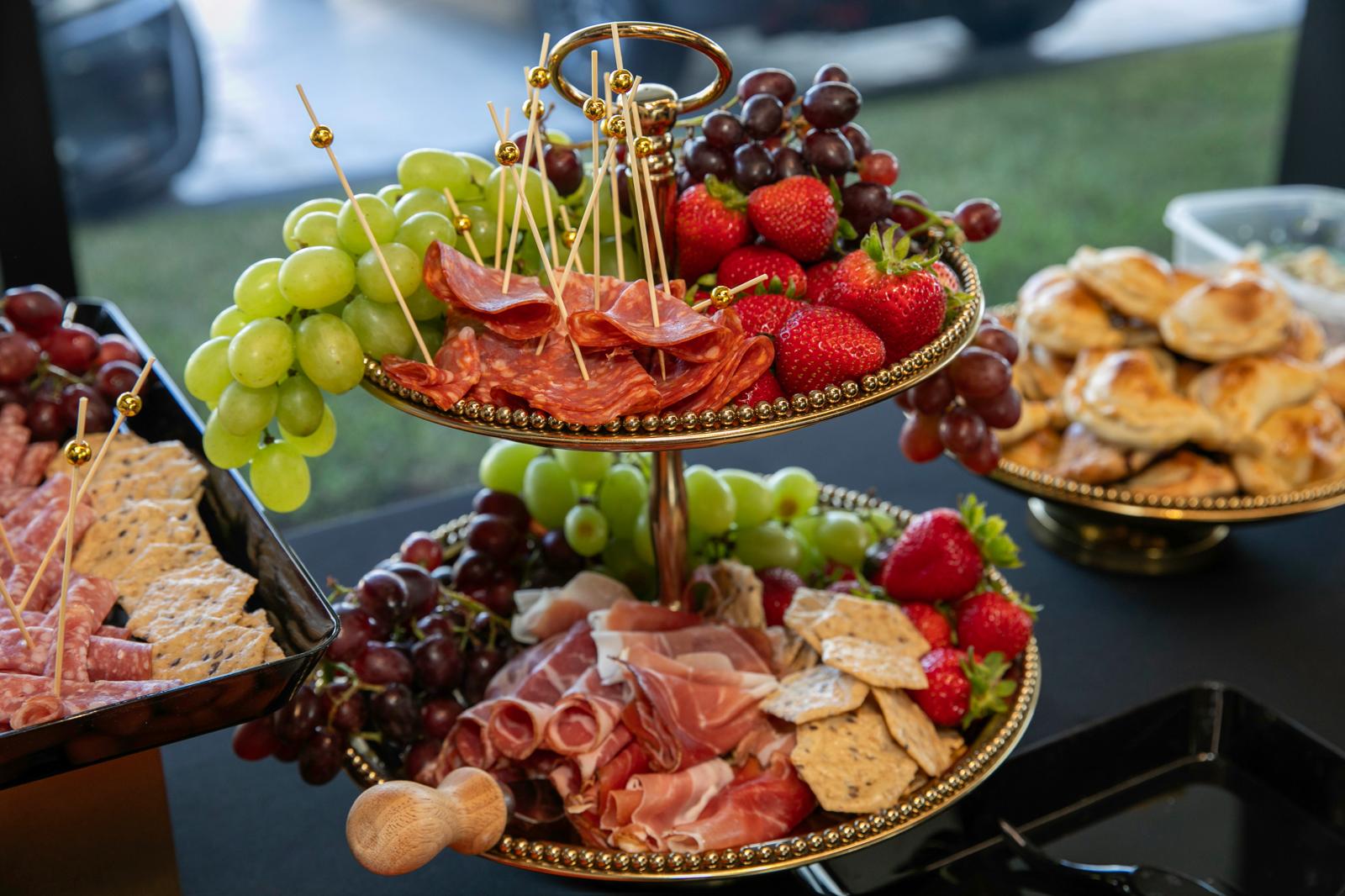 Gold tiered stand with prosciutto, salami, grapes and berries