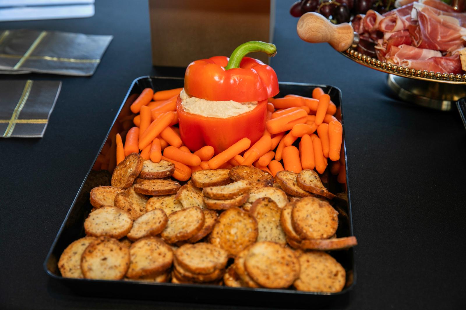 Crudite tray with hummus served in a red pepper