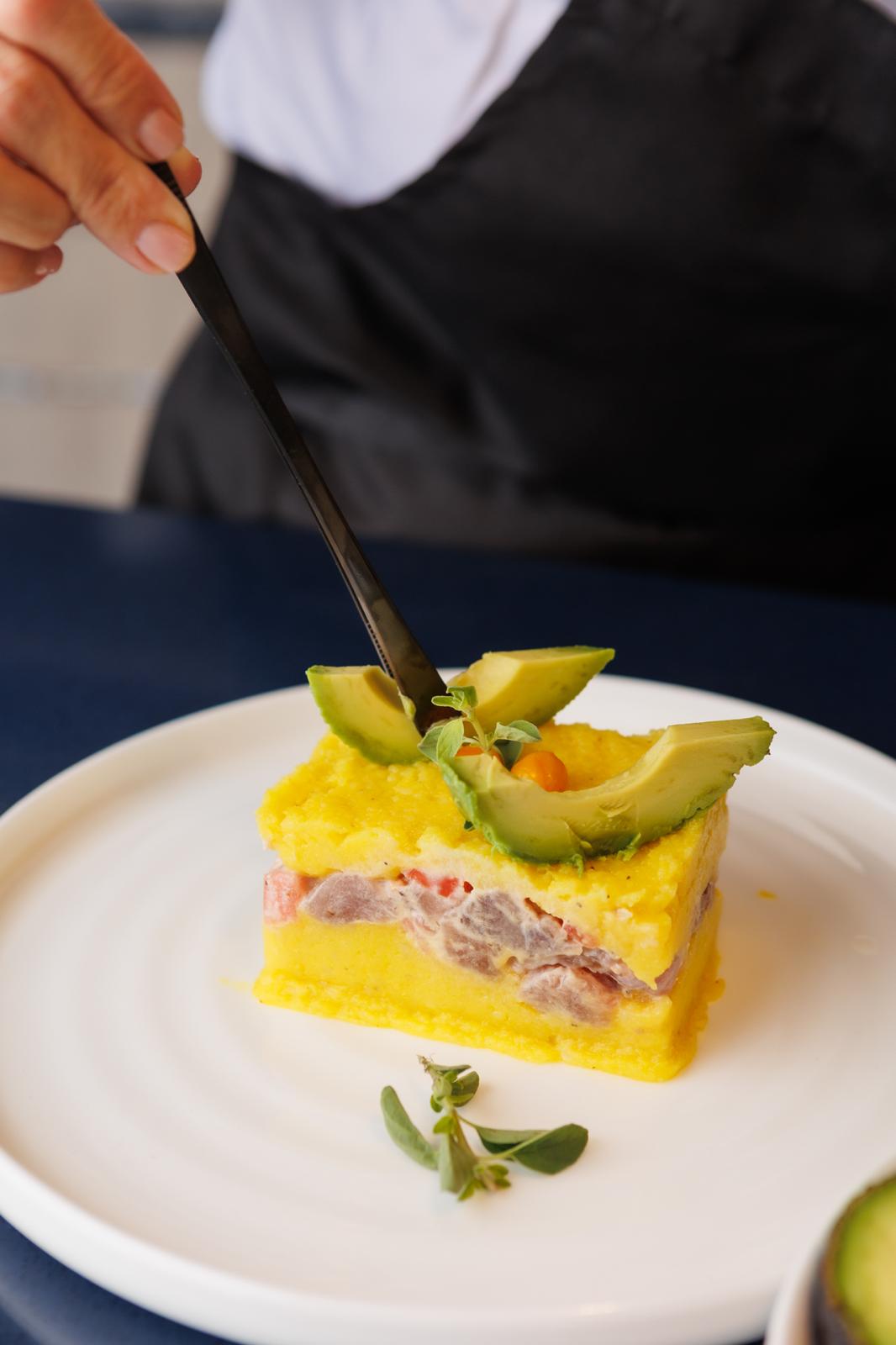 Layered causa with avocado and fresh herbs