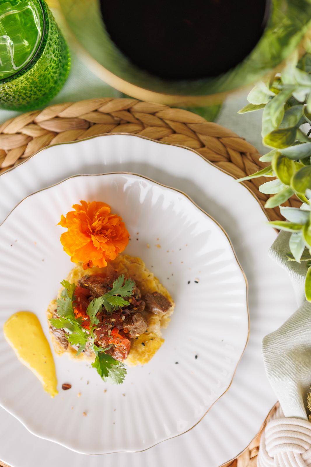 Plated beef dish with edible flower on fine china