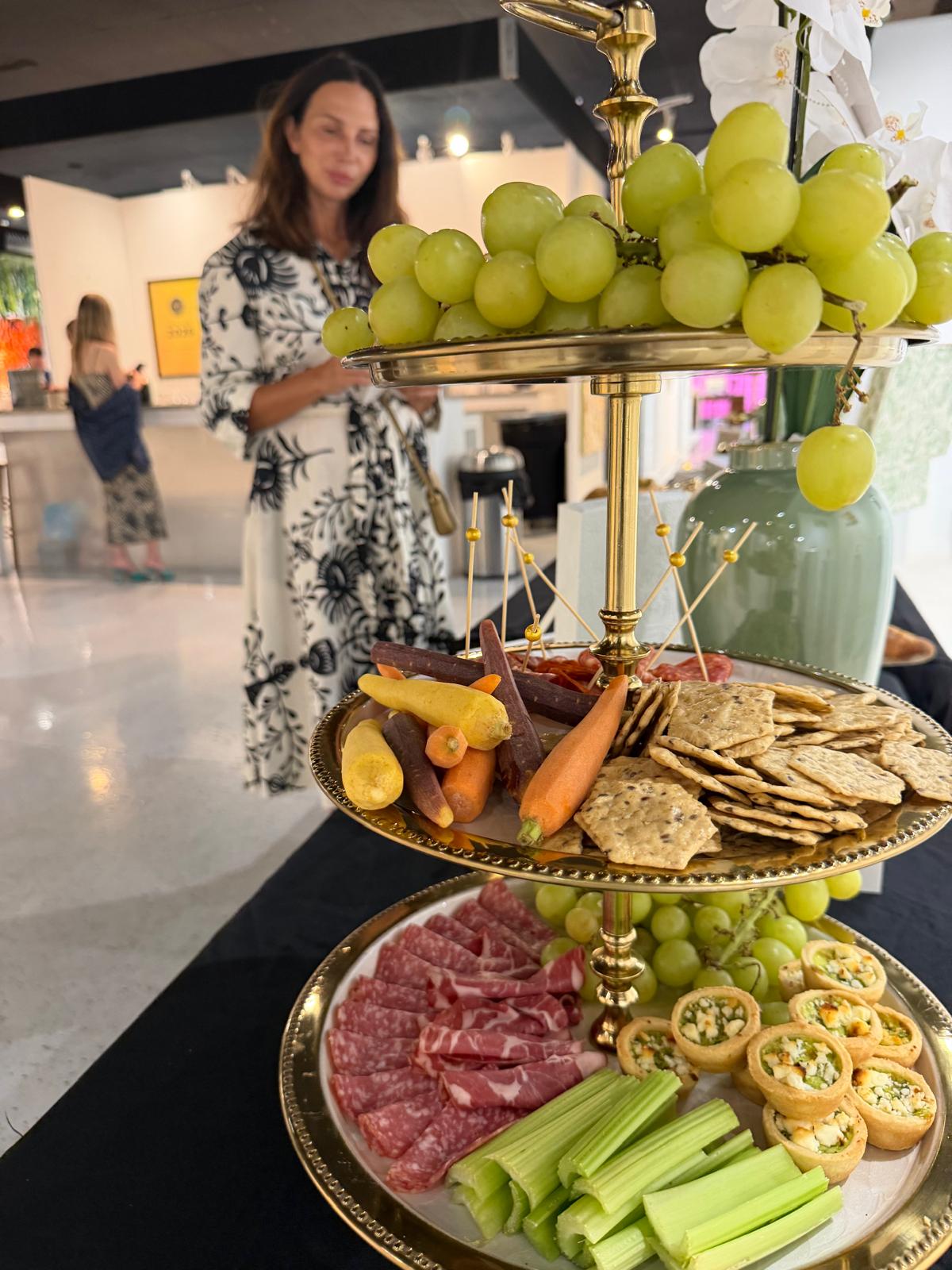 Tiered gold stand with grapes, charcuterie and canapes
